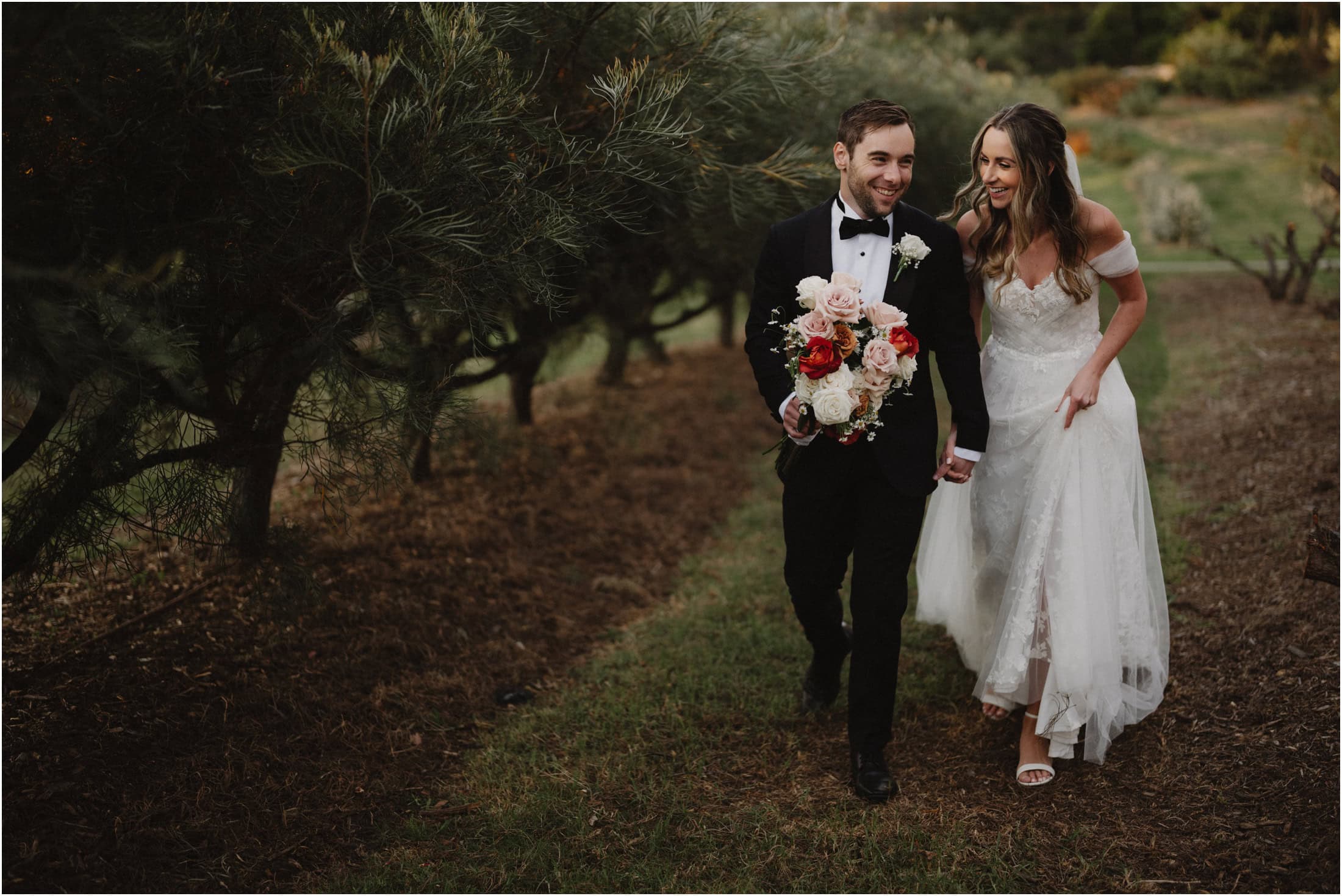 A newly married couple walk through the rows of flowers during their Growwild Wildflower Farm wedding